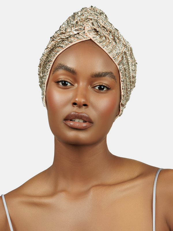 Female model wearing handmade silver sequin and palette embroidered blush colored turban designed by Maryjane Claverol